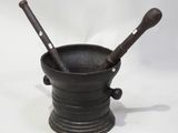 an old mortar with two wooden spoons in it on a white background