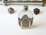 a glass bottle sitting on a table next to other items