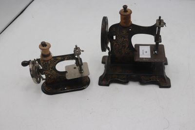 deux vieilles machines à coudre posées sur une surface blanche