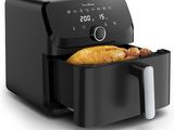 une friteuse à air chaud noire contenant une miche de pain
