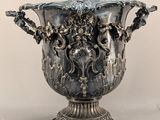 a silver vase that is sitting on a table