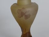 a glass vase with a flower on it on a white surface