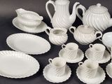 a lot of white dishes and cups on the table