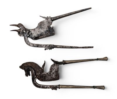 Deux vieux outils en métal sont posés sur une surface blanche.