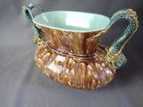 a brown and green vase with two handles on it