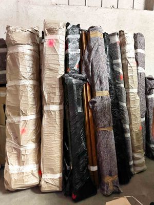 many rolls of fabric sitting on the floor in a warehouse