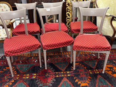 Plusieurs chaises sont alignées sur un tapis dans une pièce