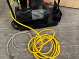 an image of a small air compressor sitting on top of a cement floor