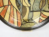 a plate with a painting on it on the wall