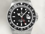rolex watch with black dial and red hands on a stainless steel bracelet
