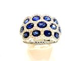 une photo d'une bague en diamant bleue et blanche posée sur une surface blanche