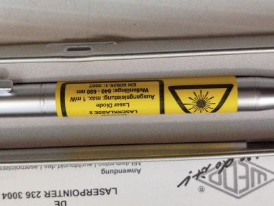 un stylo posé sur une boîte sur laquelle est collé un autocollant