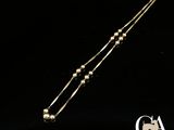 gros plan d'un collier en or sur fond noir