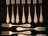 a lot of forks and spoons that are on a table