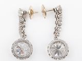a pair of diamond earrings on a white background