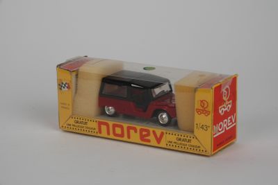 une petite voiture rouge et noire dans une boîte