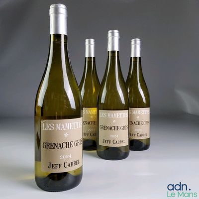 trois bouteilles de vin blanc sont alignées sur une table