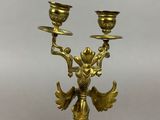 an image of a brass candle holder with a bird on it