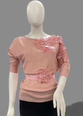 mannequin wearing a pink sweater and black pants with flowers on it