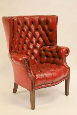 une image représentant un fauteuil en cuir rouge posé sur un sol blanc