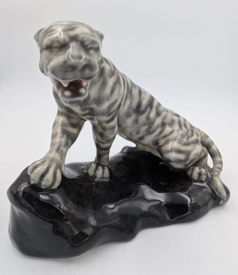 une statue représentant un chien assis sur un rocher