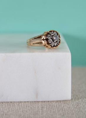 un gros plan d'une bague en diamant posée sur un bloc de marbre blanc