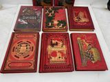 six red books are lined up on a white table