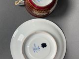 two cups and saucers are sitting next to each other on a table