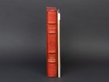 a red book sitting on top of a stack of books