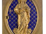 une image représentant une plaque dorée et bleue sur laquelle figure une statue de Jésus