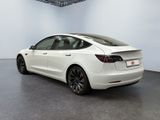 the tesla model 3 is parked in a white room