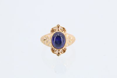 une bague en or avec une pierre bleue au centre