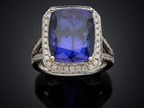 a blue sapphire and diamond ring on a black surface
