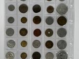 an assortment of coins in a plastic case on a white surface