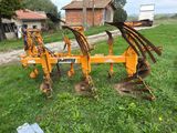 a tractor plow that is sitting in the grass