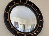 a round mirror hanging on the wall in a room