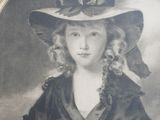 portrait of a young girl wearing a large hat and a black dress