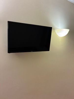 une télévision à écran plat fixée au mur au-dessus d'un lit