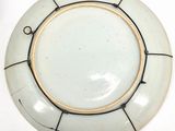 a white plate with a gold rim on a white table