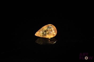 une image représentant un diamant jaune posé sur une surface noire