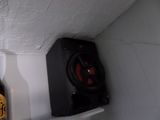 a bottle of beer sitting on a shelf next to a speaker