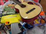 a guitar that is sitting in a pile of toys