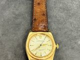 a close up of a wrist watch with a brown leather strap