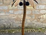 a palm tree made out of bamboo sticks on a metal stand