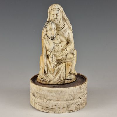 une figurine en ivoire sculpté représentant une femme tenant un enfant dans ses bras