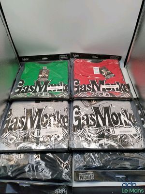 Plusieurs t-shirts sont empilés les uns sur les autres sur une étagère