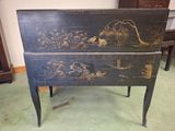 a black chest with a painting on it in a room