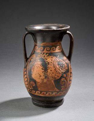 un vase noir et marron sur lequel est représenté un homme