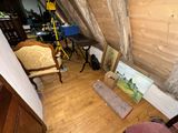 a picture of a room with a chair and pictures on the floor