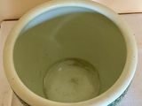 a green bowl sitting on top of a white table